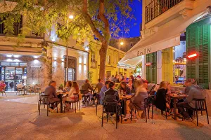 Awning Prints: View of restaurant and bar in Dalt Vila at dusk