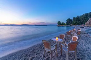 Chairs Prints: View of restaurant tables on beach after sunset