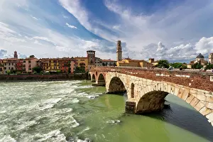 Riverside Prints: View of River Adige and Ponte Pietra in Verona with buildings and clouds in the background during the day