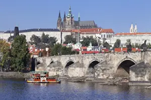 View over the River Vltava with excursion boat to Charles Bridge and the Castle District with St. Vitus Cathedral and Royal Palace, UNESCO World Heritage Site, Prague, Bohemia, Czech Republic, Europe