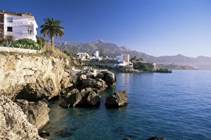 View along rocky coast to town and mountains