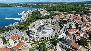 Attractions Prints: View of the Roman amphitheatre in Pula surrounded by buildings and nature under a clear sky in Croatia