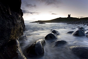 View across the Rumble Churn at dawn towards the ruins of Dunstanburgh Castle
