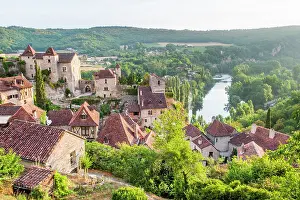 Riverside Prints: View of Saint-Cirq-Lapopie village overlooking Lot River in Midi-Pyrenees region in France