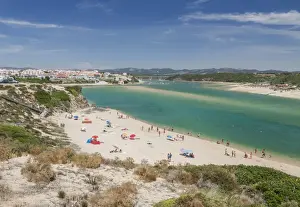 Beach Resort Prints: View of the sandy beach of Vila Nova de Milfontes surrounded by the turquoise ocean