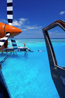 Swimming Prints: View from a seaplane cockpit of man swimming, Maldives, Indian Ocean, Asia