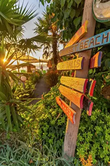 Waterfront Dining Prints: View of signpost in old harbour in Thassos Town during golden hour