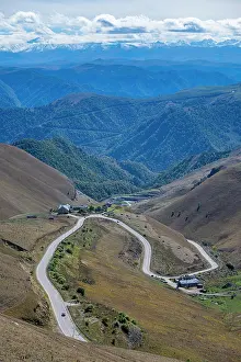 Altitude Prints: View from the slopes of Mount Elbrus showcasing winding roads and mountainous terrain in the Caucasus range of Russia