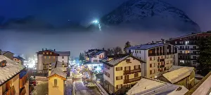 Chalet Prints: View of snow covered rooftops with mountainous background at dusk