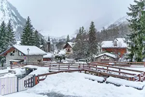 Aosta Prints: View of snow covered wooden houses and church in Entreves in winter