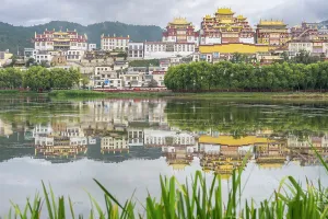 Retreat Prints: View of Songzanlin Monastery reflected in Lamuyangcuo Lake with surrounding greenery in Yunnan