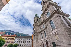 Innsbruck Prints: View of St. Jakob Cathedral standing tall in Innsbruck surrounded by buildings under a sky with clouds in Tyrol Region