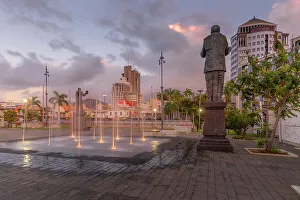Water Fountain Prints: View of statue in Caudan Waterfront in Port Louis at dusk