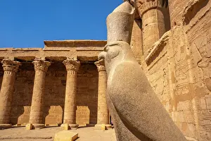 Symbolism Prints: View of statue of Horus the falcon outside the doorway to the sandstone Temple of Horus at Edfu