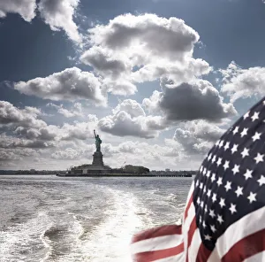 Flag Prints: View of Statue of Liberty from rear of bot with Stars and Stripes flag