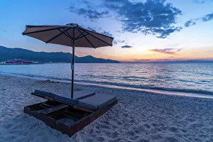 Sunset Colors Prints: View of sun lounger on the beach and Aegean Sea after sunset