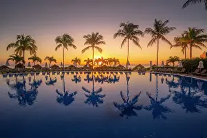 Swimming Pool Prints: View of sunrise and palm tree reflections in hotel pool near Puerto Morelos