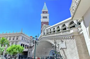 Corridor Prints: View of a tall clock tower and bridge under a clear blue sky with buildings in the background