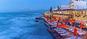 Chairs Prints: View of taverna at dusk with sea and beach chairs in Limenas Chersonisou, Crete, Greece