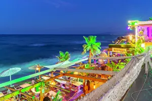 Nightlife Prints: View of taverna overlooking the sea at dusk in Crete Greece with lights and palm trees