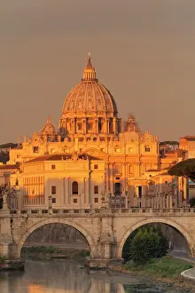 View over Tiber River to Ponte Vittorio Emanuele II Bridge and St. Peters Basilica at sunrise