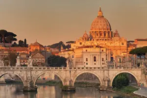 View over Tiber River to Ponte Vittorio Emanuele II Bridge and St. Peters Basilica at sunrise