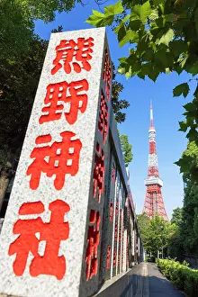 Tokyo Prints: View of Tokyo Tower behind a stone wall with Kanji inscriptions in the daytime in Tokyo Japan