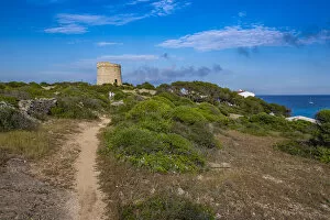 Direction Gallery: View of Torre de Son Ganxo and lighthouse on Illa de I Aire, Punta Prima, Menorca