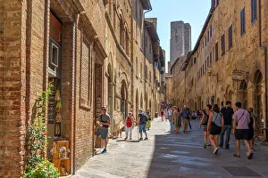Pedestrians Prints: View of towers from narrow street in San Gimignano