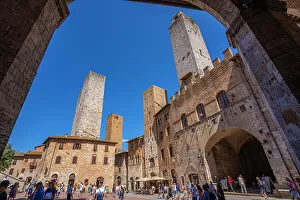 Pedestrians Prints: View of towers and Piazza del Duomo in San Gimignano