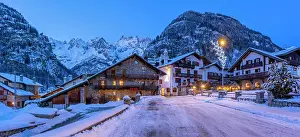 Snowflakes Prints: View of town centre and snow covered mountains in background at dusk