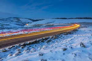 View of trail lights on frozen landscape near Buxton at dusk, High Peak, Derbyshire
