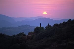 View of Tuscan hill top town with setting sun, Tuscany, Italy, Europe
