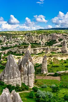 Cappadocia Prints: View of unique rock formations in Rocket Valley in Cappadocia with clear sky and green landscape during daytime
