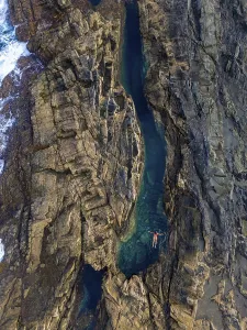 Females Prints: Top view of an unrecognizable woman floating peacefully in a natural pool amid rugged cliffs at Tindaya Beach