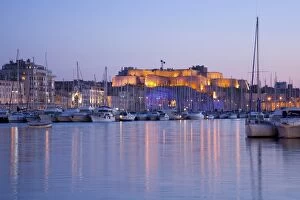 View across the Vieux Port to the illuminated Fort St.-Nicolas at dusk