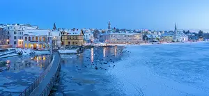 Cozy Prints: View of waterfront buildings and city skyline in background in the city centre of Reykjavik at dusk in winter
