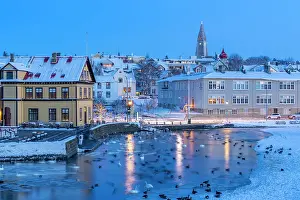 Centre Prints: View of waterfront buildings and city skyline in background in the city centre of Reykjavik at dusk in winter