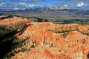 Bryce Prints: Views from a high point in Bryce Canyon reveal red rock formations and distant mountains under a bright sky in Utah