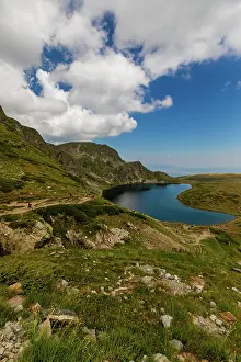 Body Prints: Views of Kidney Lake in Rila Mountains feature rocky slopes and grassy hills on a sunny day