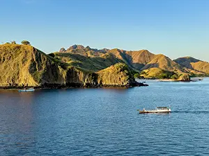 Navigation Prints: Views of Komodo Island showcasing the natural landscape and boat activities on the water during daylight hours
