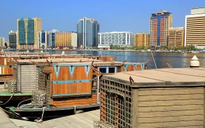 Attractions Prints: Views showing traditional boats along Dubai Creek with modern buildings in the background during a sunny day in Dubai