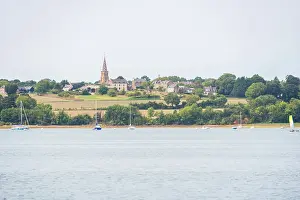 Sailboats Prints: Village church spire above green hills overlooking the Rance River in Brittany France with boats in the foreground
