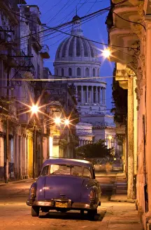 El Capitolio Prints: Vintage American car parked on floodlit street with The Capitolio in the background