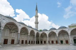 Courtyard Prints: Visit to the Blue Mosque featuring a tall minaret in the heart of Istanbul with people exploring the courtyard
