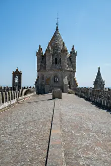 Preservation Prints: Visit the landmark structure at the Cathedral of Evora with grand towers and a long pathway in the distance in Portugal