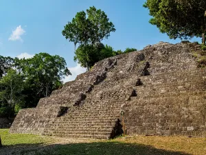 Remnants Prints: Visit to North Acropolis at Yaxha Archaeological Site in Guatemala with ancient steps leading up to ruins under a clear
