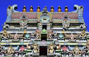 Sculptures Prints: Visitors admire the detailed architecture of Arul Mihu Navasakthi Vinayagar Temple in Seychelles during a sunny day