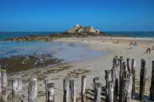 Brittany Prints: Visitors enjoy the beach and view of the walled city near the sea in Brittany