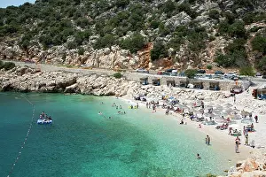 Umbrellas Prints: Visitors enjoy the sun and water at Kaputas Beach in Turkey during a summer day